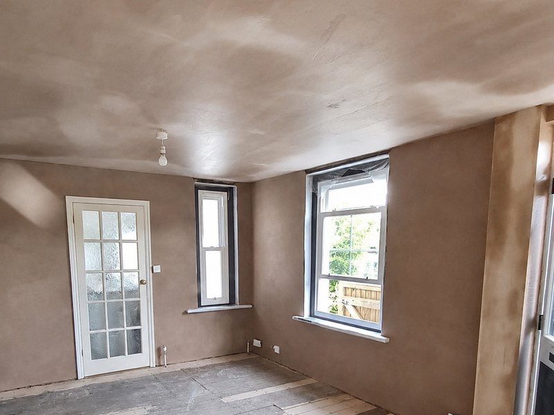 A freshly skimmed room in Kent with walls, ceiling and window reveals finished, plaster still drying