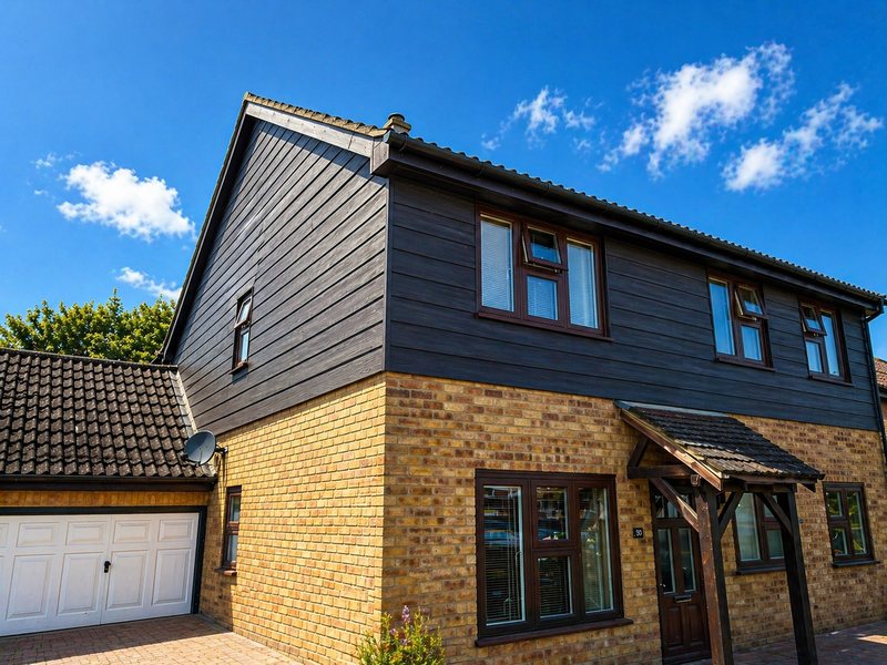Dark cladding to the gable and first floor of a detached house in Kent