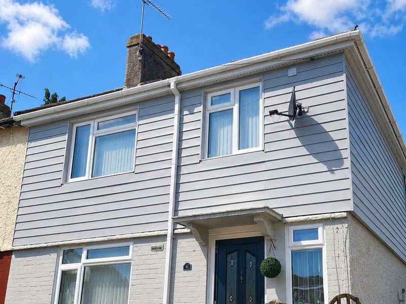 Light grey cladding across the full front elevation of a semi-detached house