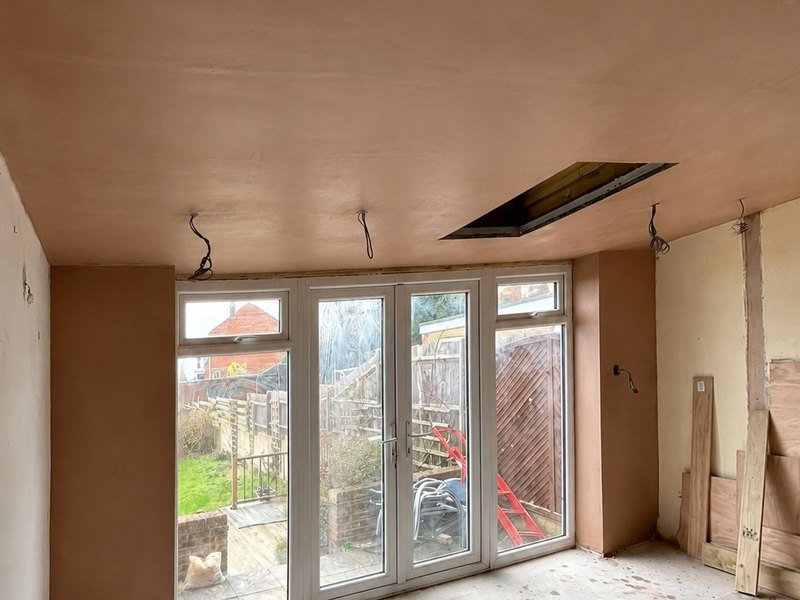 A freshly skimmed room with patio doors, walls and ceiling finished