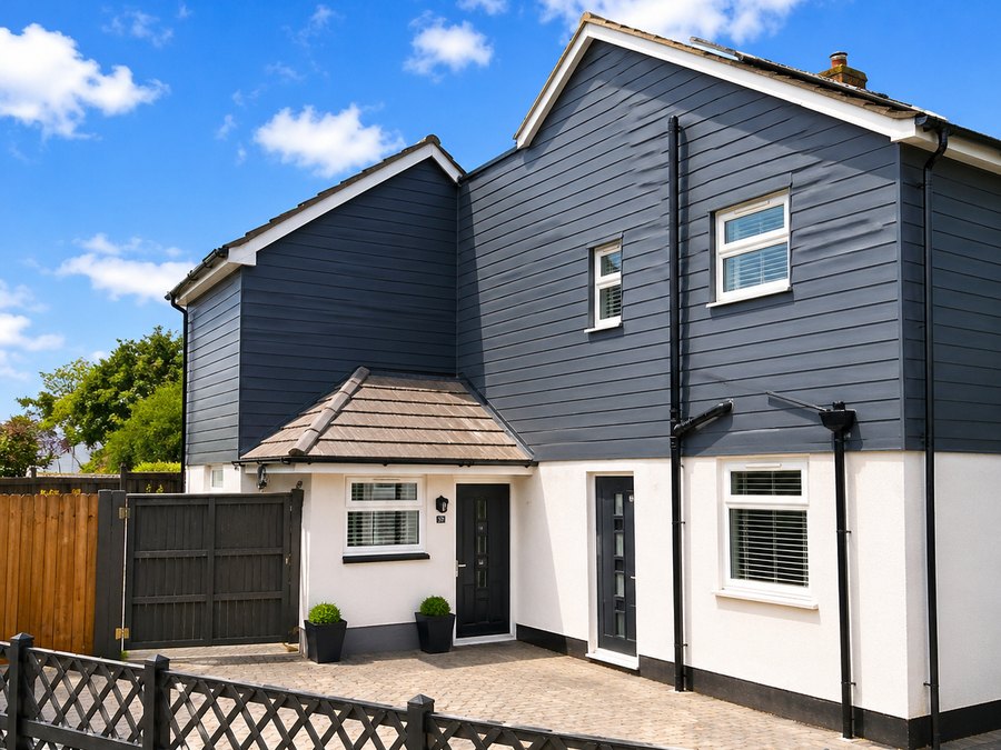 The same property completed, with white silicone render to the ground floor and dark cladding above