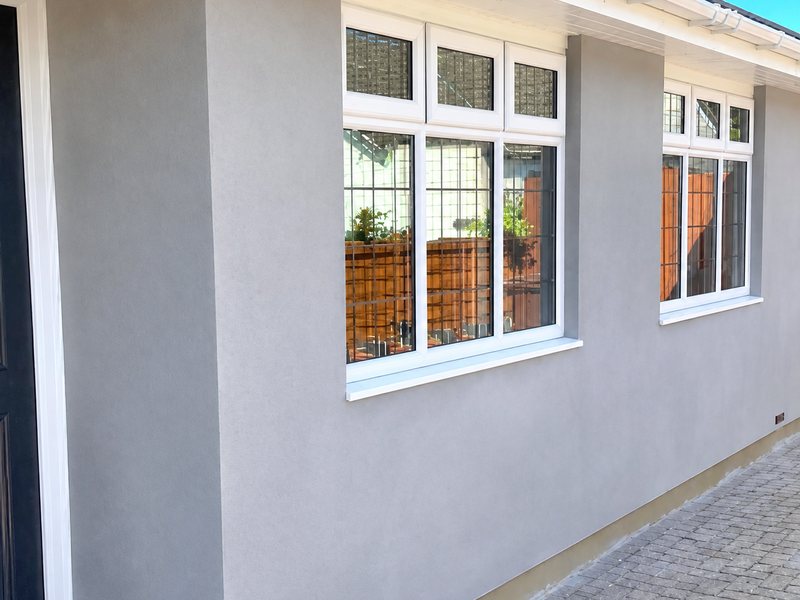A smooth grey silicone rendered elevation with clean white window reveals
