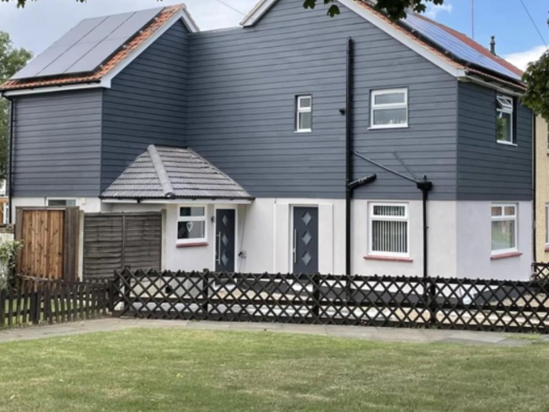 A pair of semi-detached houses with render below and dark cladding above